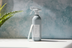 Eco-friendly cleaning supplies on a modern kitchen counter with plants and natural light.