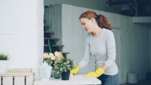 Woman in yellow gloves cleaning a table