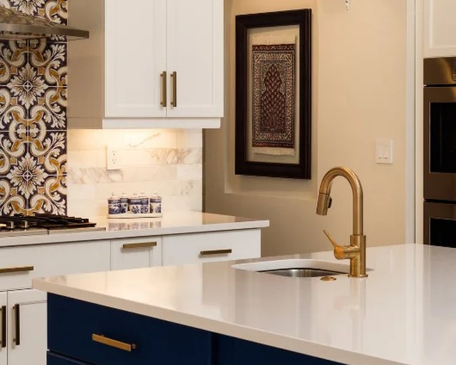 Spotless kitchen with white counters and brass faucet ready for move-in