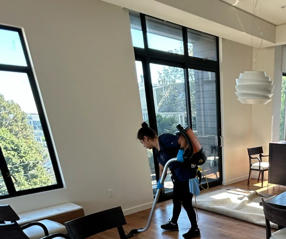 Royal Glow team member cleaning a bright home with large windows