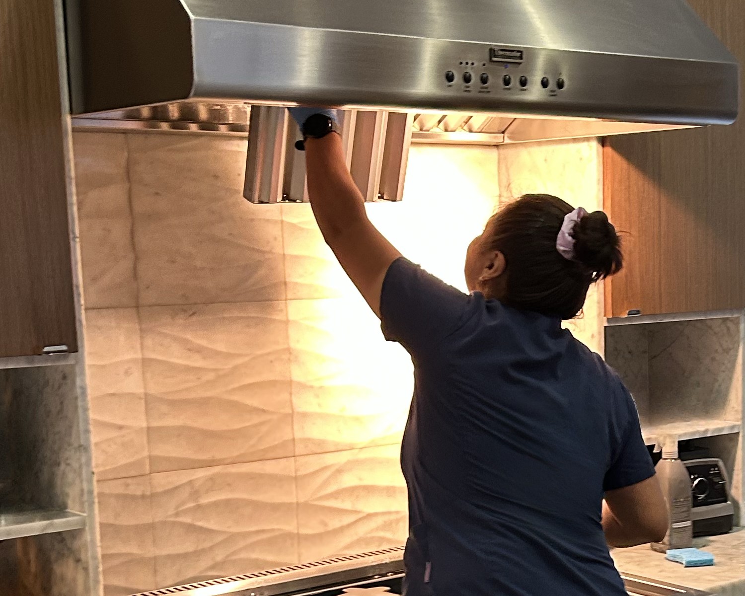 Royal Glow cleaner degreasing a stainless range hood in a Burlingame kitchen