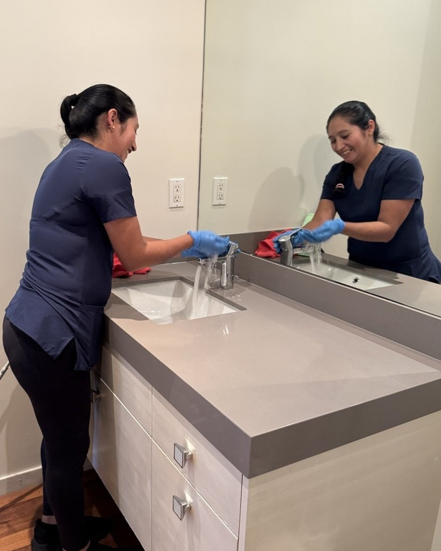 Royal Glow Cleaning team member cleaning a bathroom sink
