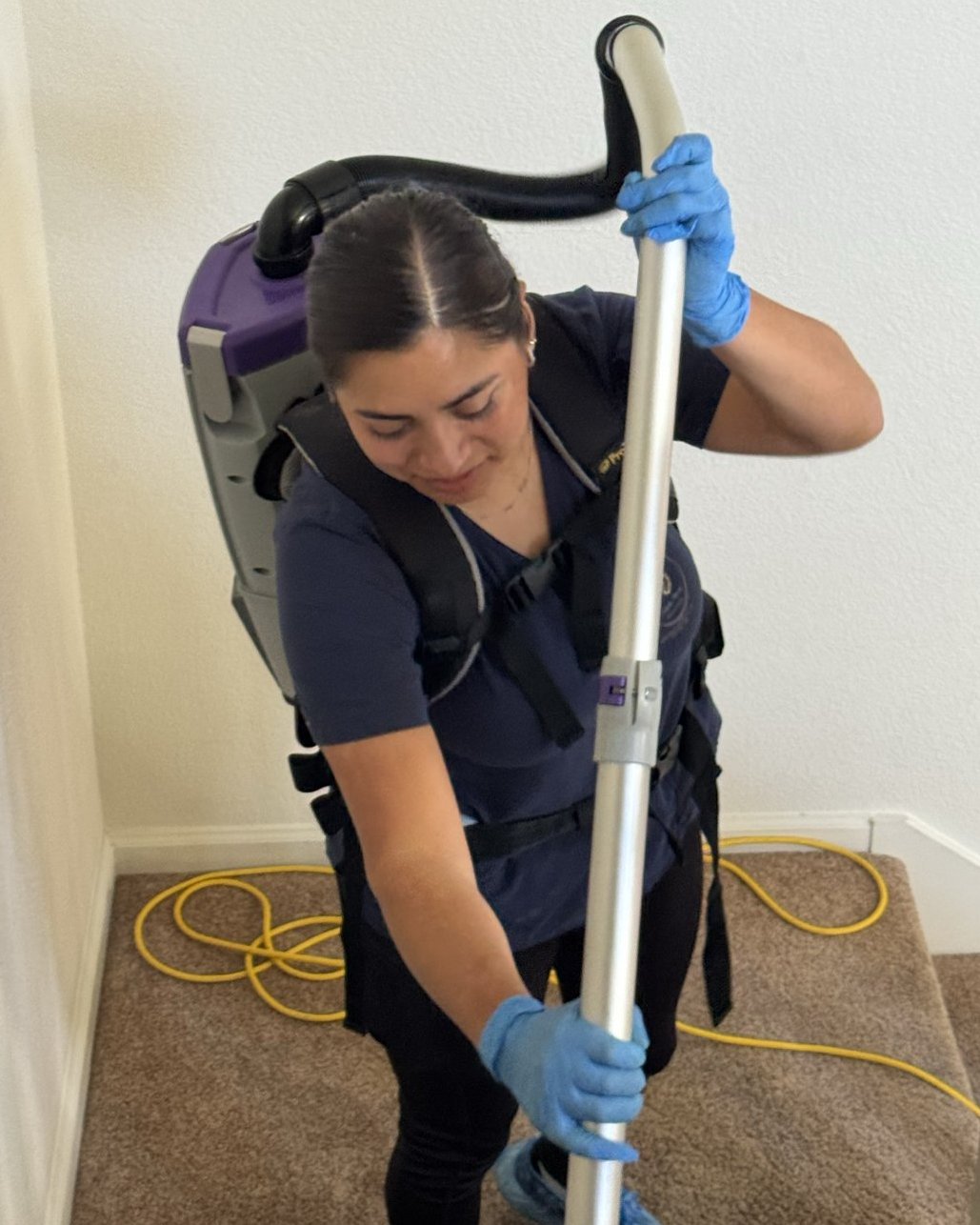Royal Glow Cleaning team member vacuuming with a backpack vacuum