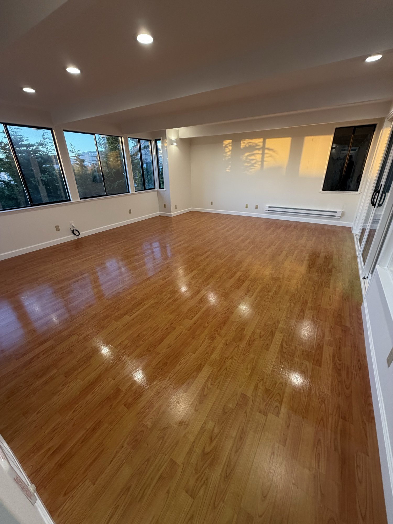 Empty living room with freshly cleaned shiny wood floors after a Royal Glow move-out clean